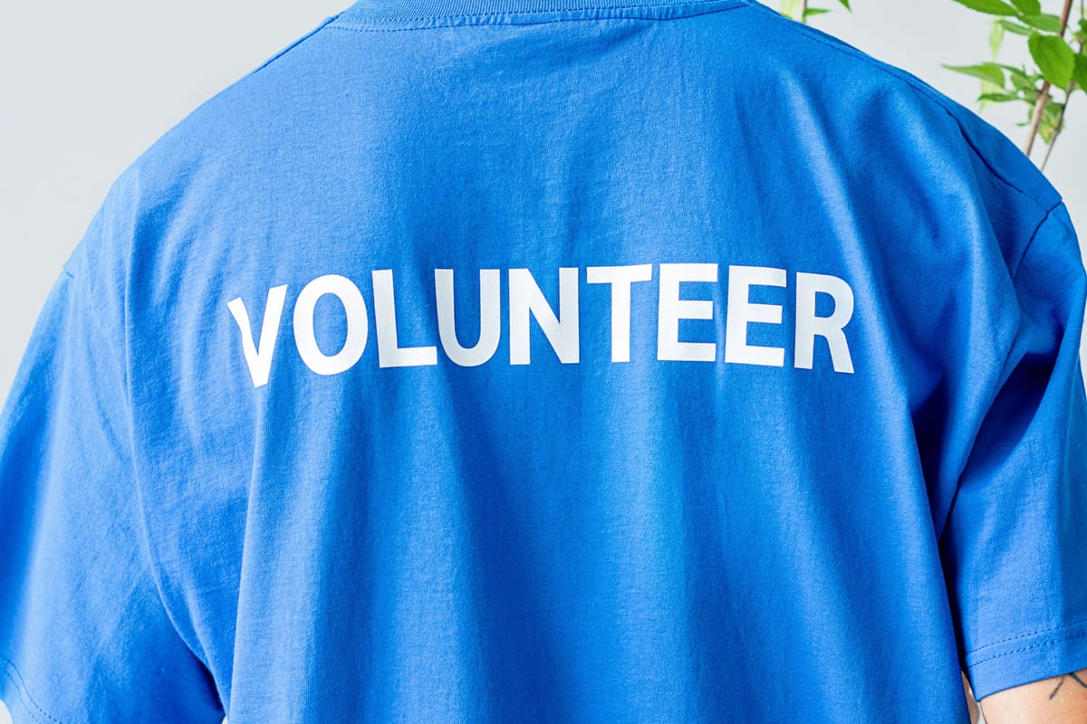 Printed white lettering across the back of a blue t-shirt, sitting flat on the fabric